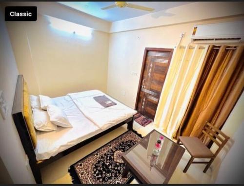 a small bedroom with a bed and a table at Hotel Green Villa in Rewa