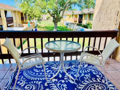 a glass table and two chairs on a balcony at Spacious Condo close to Siesta in Sarasota