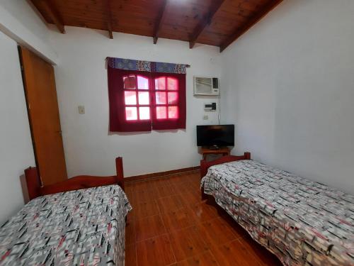 two beds in a room with a window at Surubí Sur in Goya