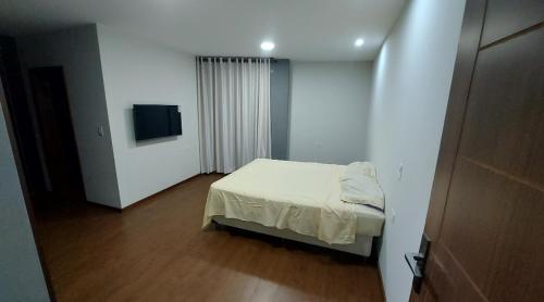 una piccola camera con letto e televisore di Hermoso y acogedor departamento a Sucre