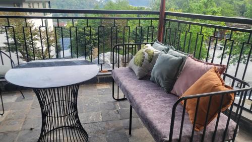 a couch and a table on a balcony with a view at Lotus Premium Lodge - Lotus Group Tours in Ha Giang