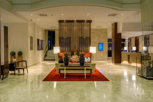 a lobby with a couch on a red rug at Crowne Plaza Nairobi Airport by IHG in Nairobi