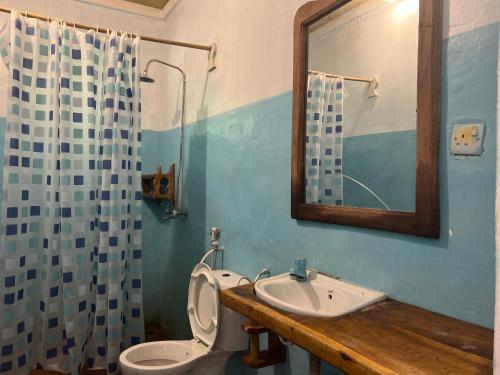 ein Badezimmer mit einem WC, einem Waschbecken und einem Spiegel in der Unterkunft Afro Rooms & Tents in The Beach in Kilindoni