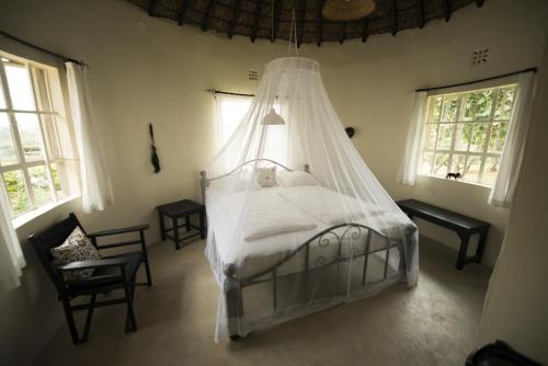 a bedroom with a bed with a mosquito net at Nyati Hill Cottages in Nairobi