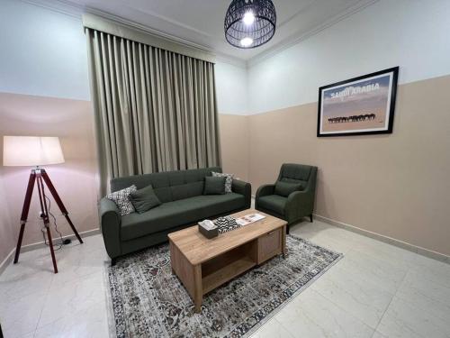 a living room with a couch and a coffee table at بوتيك هاوس بدخول ذاتي وصالة أنيقة in Hail