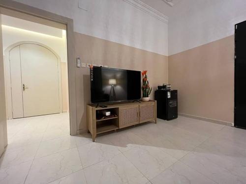 a living room with a flat screen tv on a stand at بوتيك هاوس بدخول ذاتي وصالة أنيقة in Hail