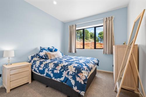 a bedroom with a bed and a window at The Terraces - Pauanui Holiday Home in Pauanui