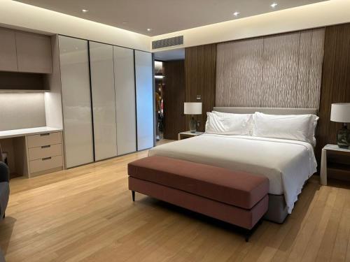 a bedroom with a large bed and a ottoman at Imperial lexis KLCC By AR Hospitality in Kuala Lumpur