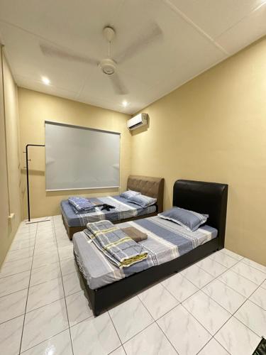 - 2 lits dans une chambre avec un écran de projection dans l'établissement Tabuan Jaya Keranji Home w Wi-Fi&Aircon, à Kuching