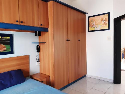 1 dormitorio con 1 cama y armario de madera en The roof garden, en Marsaskala
