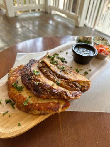 a wooden plate with three pieces of food on a table at Looking Good Surf House San Juan del Sur in San Juan del Sur