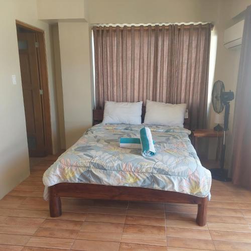 Una cama con un teléfono sentado encima. en captngreggs dive resort en Puerto Galera