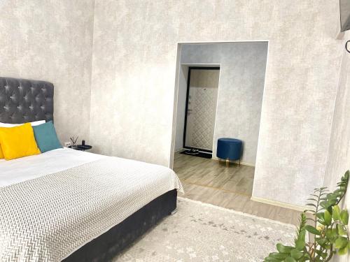 um quarto com uma cama com uma almofada amarela e azul em Комфортные апартаменты на ЭКСО em Prigorodnyy