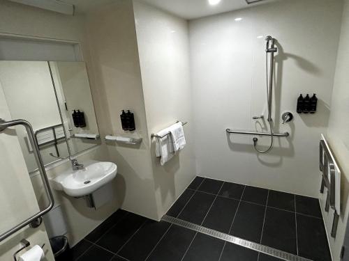a bathroom with a sink and a toilet and a mirror at Ibis Darwin Airport Hotel in Darwin