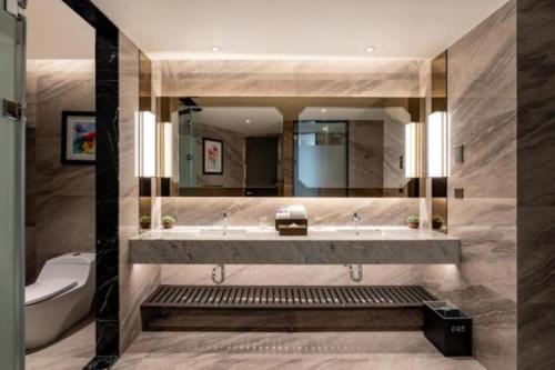 a bathroom with a tub and a toilet and a mirror at Imperial lexis KLCC By AR Hospitality in Kuala Lumpur
