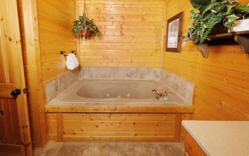 Habitación de madera con baño con bañera. en Legacy Views and A Theater, en Sevierville