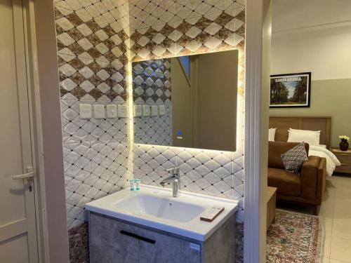 ein Bad mit einem Waschbecken und einem Spiegel in der Unterkunft بوتيك هاوس بغرفة نوم أنيقة in Sidīs