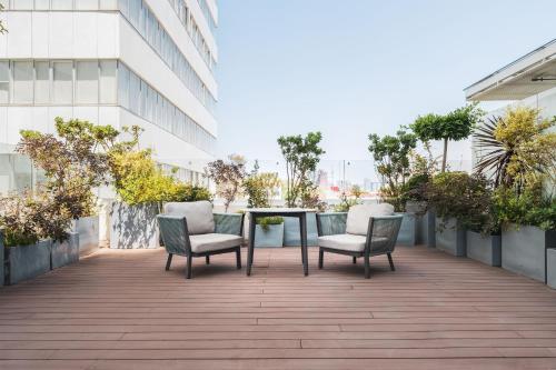 a patio with two chairs and a table on a building at Isolda Suites Vistas del Bosque in Mexico City