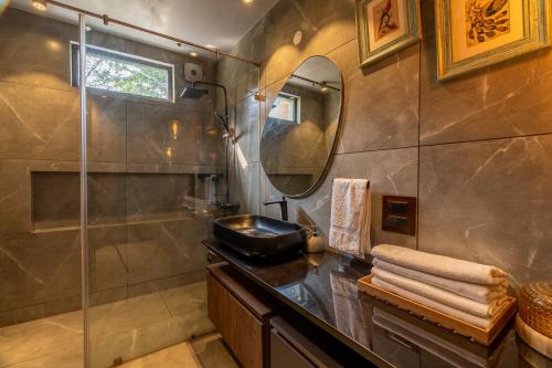 a bathroom with a shower and a sink and a mirror at SaffronStays The Hill Abode in Kasauli