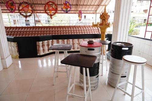 Habitación con taburetes, mesa y algunas ventanas en White Monkey en Siem Reap