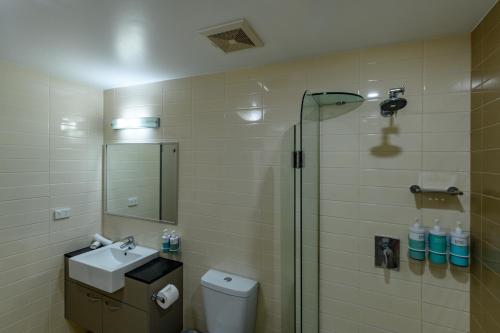 a bathroom with a shower and a sink and a toilet at Novotel Darwin Airport in Darwin