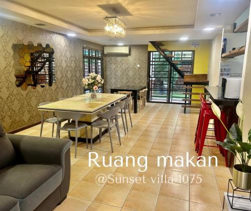 une salle à manger avec une table et des chaises ainsi qu'une cuisine dans l'établissement A Famosa Resort sunset 1075 villa 4 bathroom 6 bedroom karaoke bbq snooker, à Kampong Ulu Pegoh