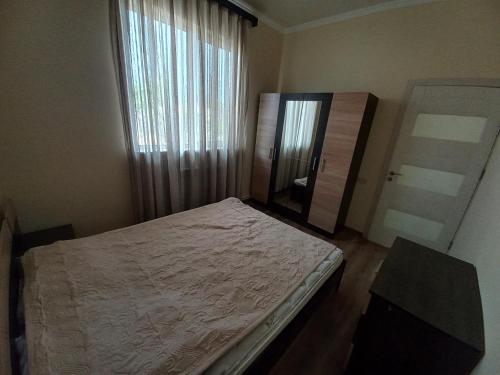 Schlafzimmer mit einem Bett, einem Spiegel und einem Fenster in der Unterkunft Sahakyan's guest house in Yerevan