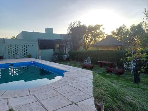 a backyard with a swimming pool and a table and benches at Los Nogales in San Rafael