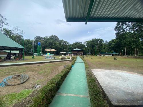 a long green walkway in a park with a building at Lapa Verde Lodge in Jaloba