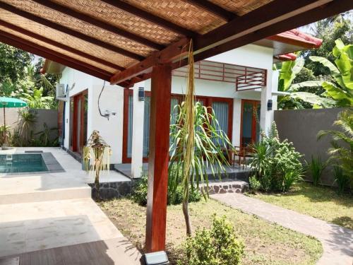 a view of a house with a wooden pergola at Private Villa Aditya Beach in Buleleng