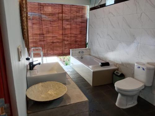 a bathroom with a tub and a toilet and a sink at Private Villa Aditya Beach in Buleleng