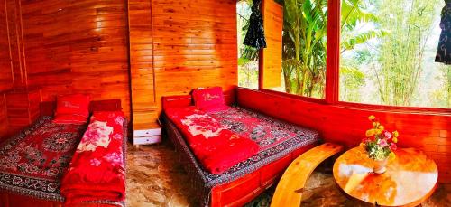 a room with two benches in a room with a window at Zoo si homestay in Sa Pa