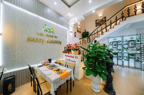 a dining room with a table and a plant at Harry Homestay in Cat Ba