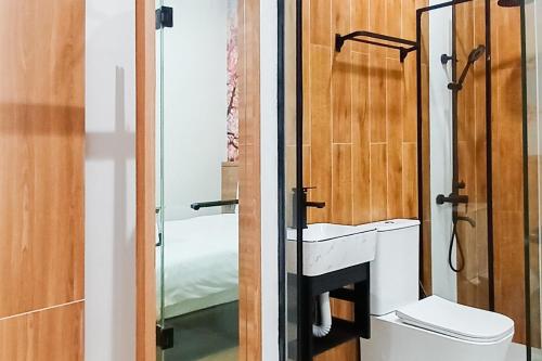 ein Bad mit einem WC und einem Spiegel in der Unterkunft Urbanview Hotel R House Batuaji in Kubuk