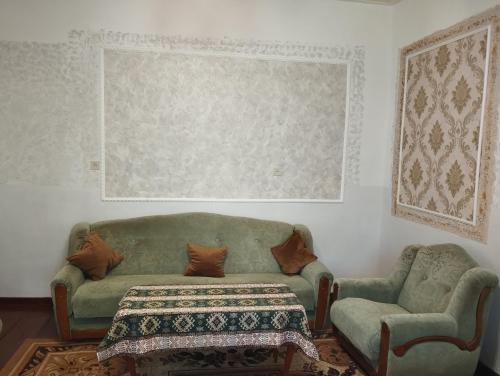 sala de estar con sofá verde y silla en Sanahin OLD&NEW, en Alaverdi