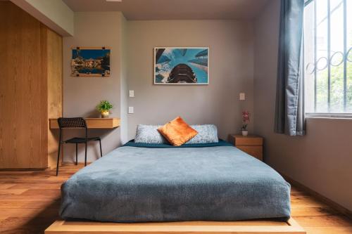a bedroom with a large bed with a blue blanket at Casa Isolda in Mexico City