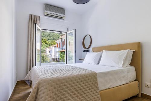 a bedroom with a bed and a balcony at Forest view villa Skopelos in Skopelos Town