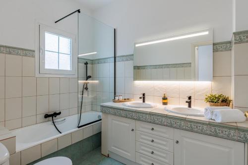 a bathroom with two sinks and a large mirror at Forest view villa Skopelos in Skopelos Town
