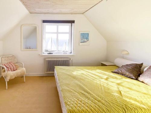 リンケビングにあるHoliday home Ringkøbing Vのベッドルーム(大きな黄色のベッド1台、窓付)