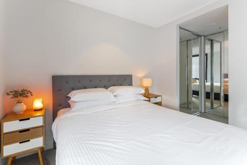 um quarto com uma grande cama branca e uma janela em Sleek Inner-City 1-Bed Pad with Pool & BBQ em Melbourne