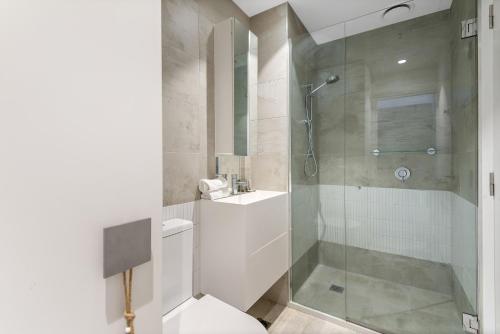 uma casa de banho com um chuveiro e um lavatório. em Sleek Inner-City 1-Bed Pad with Pool & BBQ em Melbourne