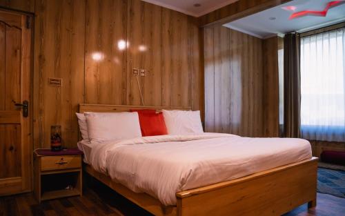 a bedroom with a large bed with wooden walls at K2 Paradise Guest house in Skardu