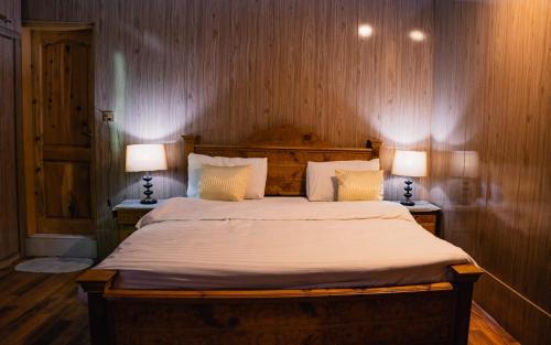 a bedroom with a large bed with two lamps at K2 Paradise Guest house in Skardu