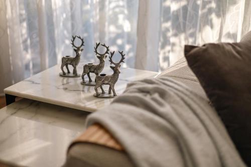 three deer figurines sitting on a table next to a couch at StayAU Cozy Holiday House 4BRM Big Group Tarneit in Tarneit
