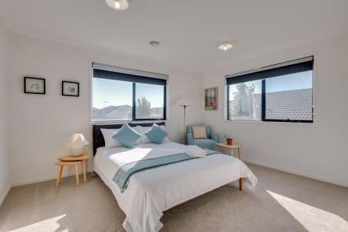 um quarto com uma cama e duas janelas em StayAU Cozy Holiday House 4BRM Big Group Tarneit em Tarneit