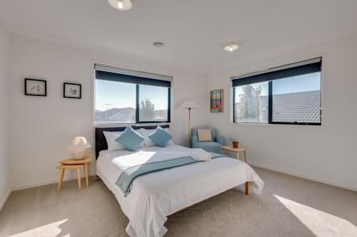 a bedroom with a bed and two windows at StayAU Cozy Holiday House 4BRM Big Group Tarneit in Tarneit
