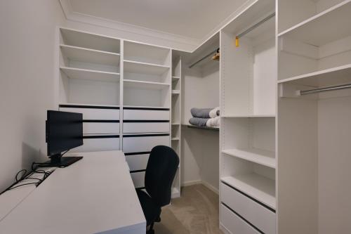 an office with a desk and a computer in a closet at StayAU Cozy Holiday House 4BRM Big Group Tarneit in Tarneit