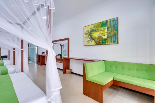 a living room with a green couch and a curtain at Treetop Resort By Scenery Villas in Dharga Town