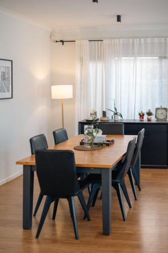 a dining room with a wooden table and chairs at StayAU Cozy Holiday House 4BRM Big Group Tarneit in Tarneit