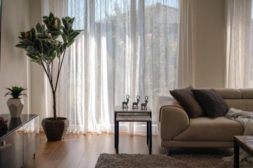 a living room with a couch and a large window at StayAU Cozy Holiday House 4BRM Big Group Tarneit in Tarneit